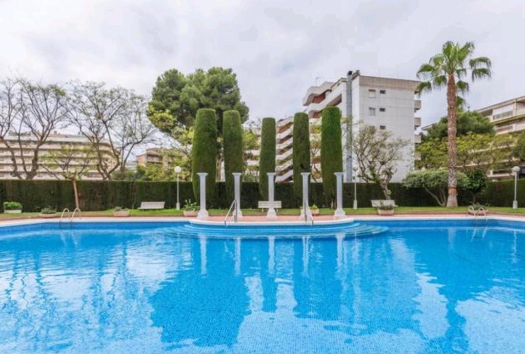 a large swimming pool with trees and a building at Marathon in Salou