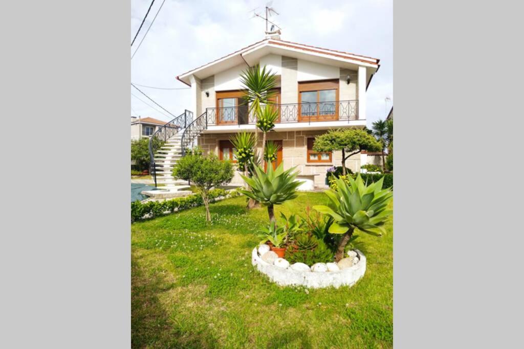 ein Haus mit Palmen im Hof in der Unterkunft Apartamento Teresa in Pontevedra