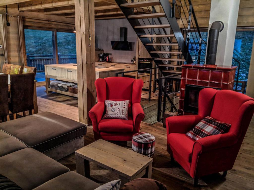 a living room with two red chairs and a couch at Chata Čerenka in Bytca