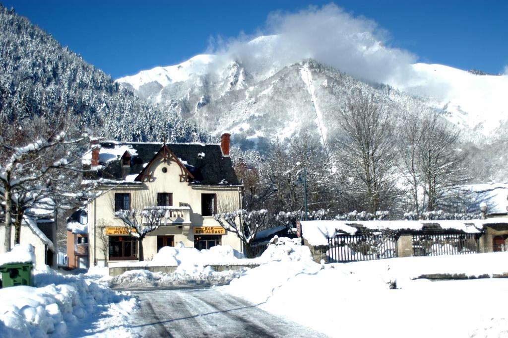 una casa cubierta de nieve frente a una montaña en Arbizonloc, en Guchen