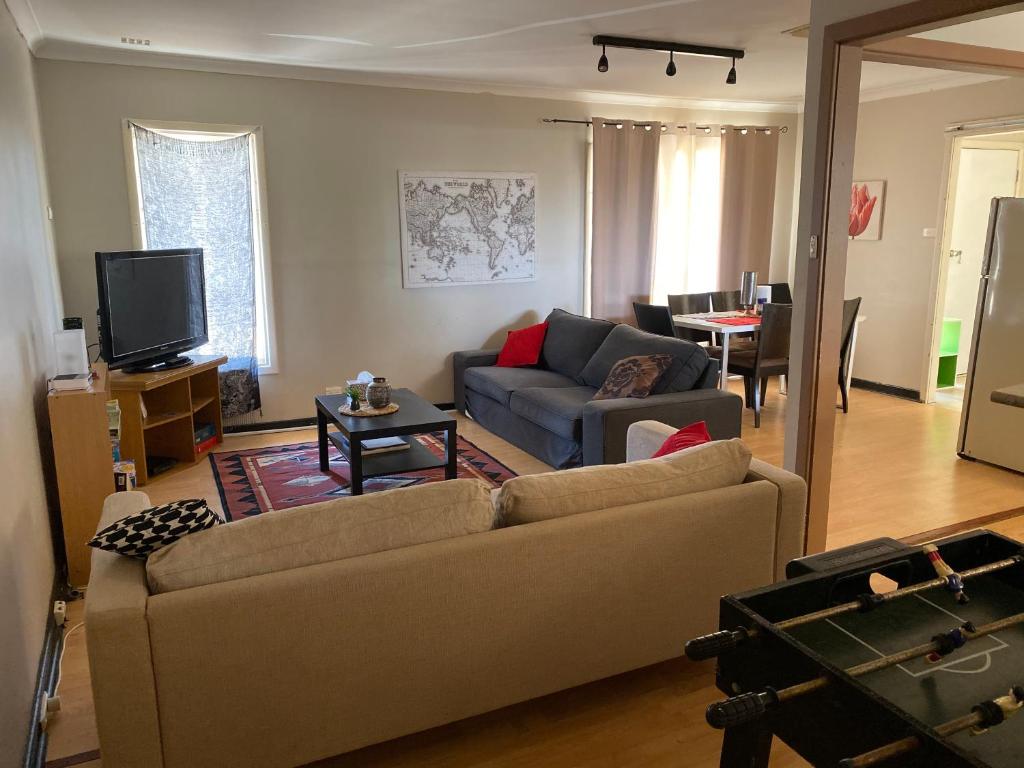 sala de estar con sofá y TV en Home away from home, en Merredin