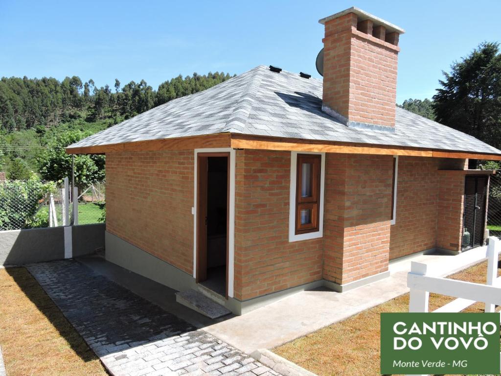 une petite maison en briques avec une cheminée au-dessus dans l'établissement Chalé Cantinho do Vovô, à Monte Verde