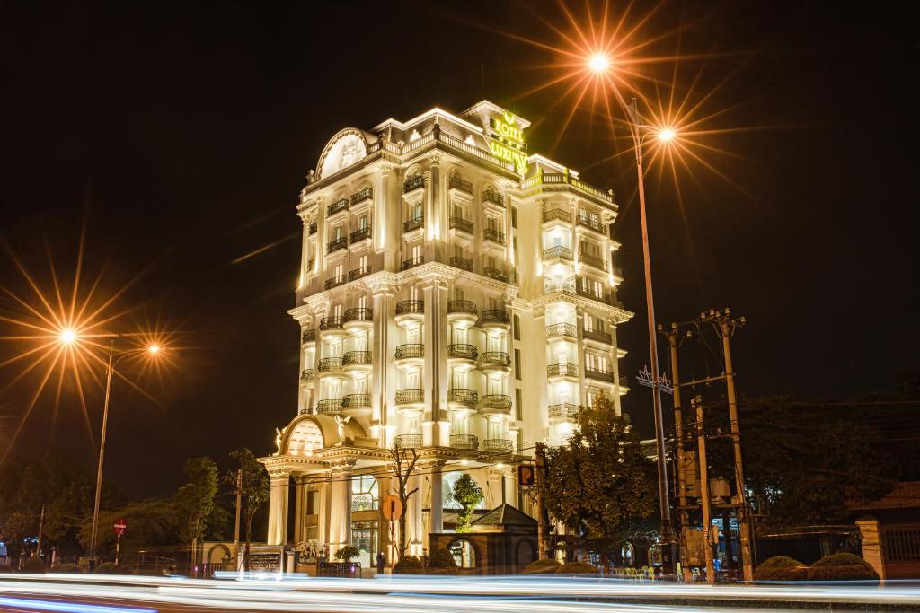 un gran edificio blanco con luces encendidas por la noche en Manh Quan Luxury Hotel en Vĩnh Yên