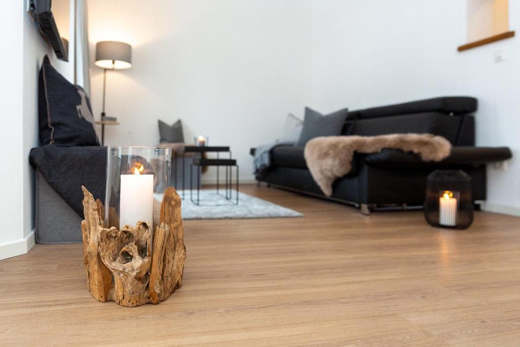 a living room with a couch and candles on the floor at Alpen-Ferienwohnung Ginova in Garmisch-Partenkirchen