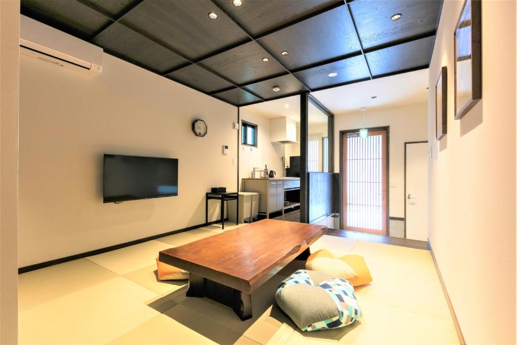 a living room with a wooden table and a tv at MUSUBI HOTEL MACHIYA Naraya-machi 1 in Fukuoka