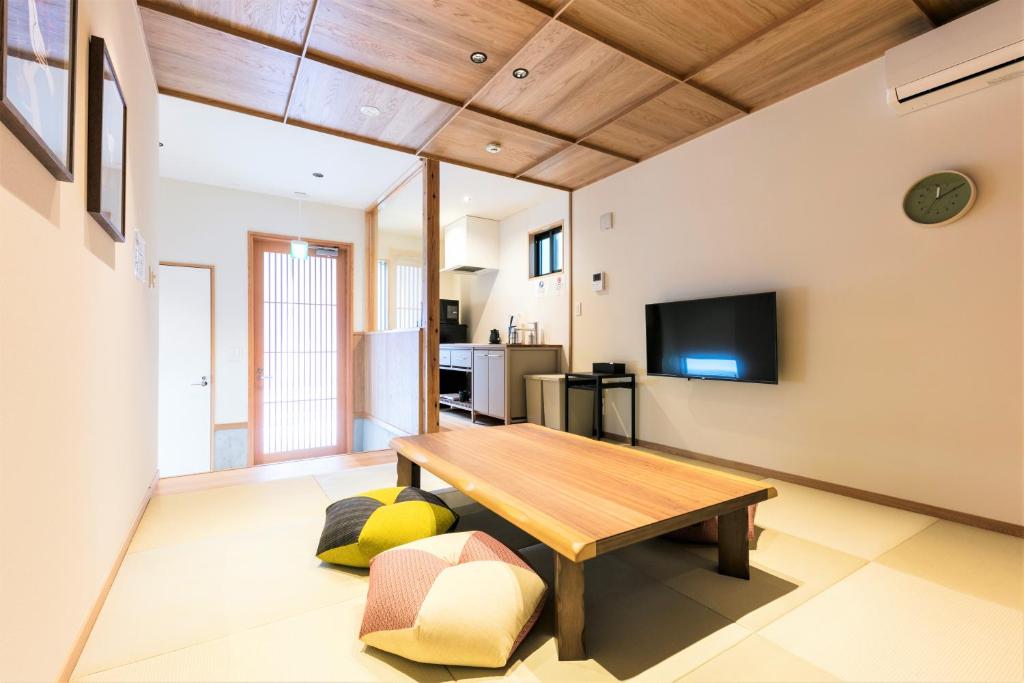 een woonkamer met een tafel en een televisie bij MUSUBI HOTEL MACHIYA Naraya-machi 2 in Fukuoka