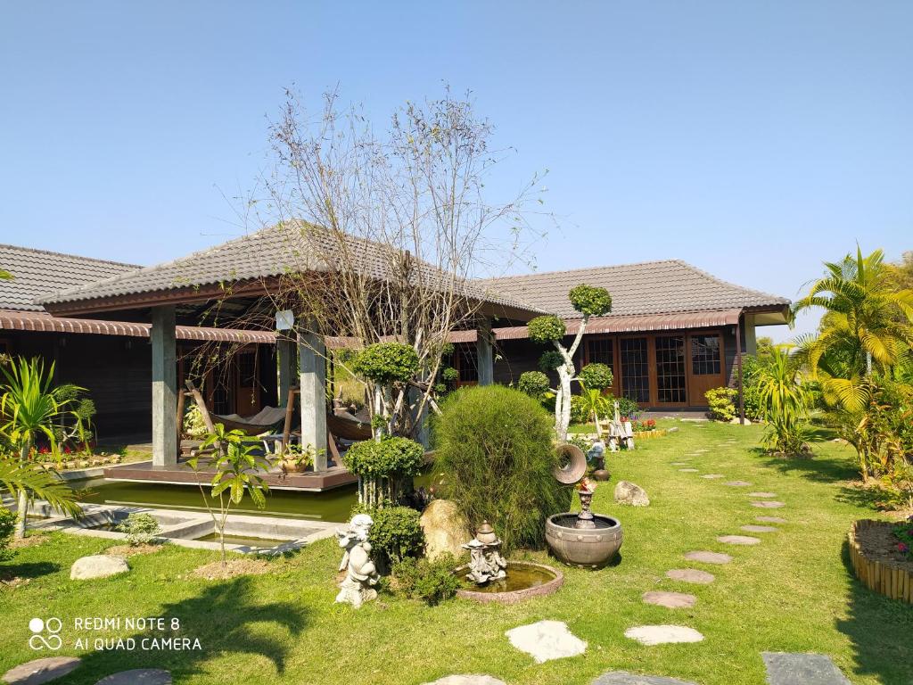 une maison avec un jardin en face dans l'établissement Angels Chambres d'hotes, à Rong Sak