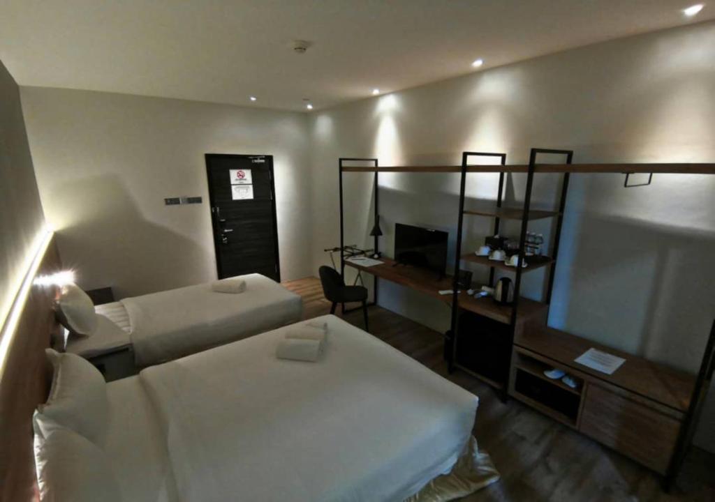 Postel nebo postele na pokoji v ubytování Roxy Hotel Padungan