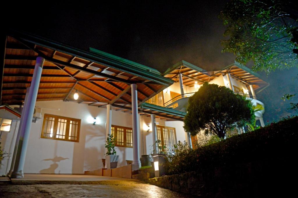 Una casa de noche con luces encendidas. en The Heritage Inn, en Kandy