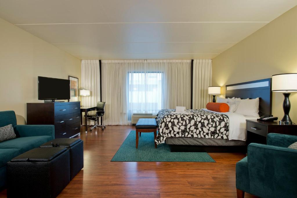 a living room filled with furniture and a flat screen tv at Hotel Indigo Atlanta Airport College Park, an IHG Hotel in Atlanta