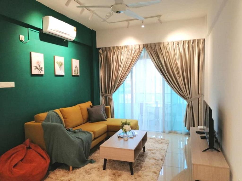 un soggiorno con divano giallo e parete verde di Furusato Midori Green 0701 Tmn Mount Austin at Johor Bahru a Johor Bahru