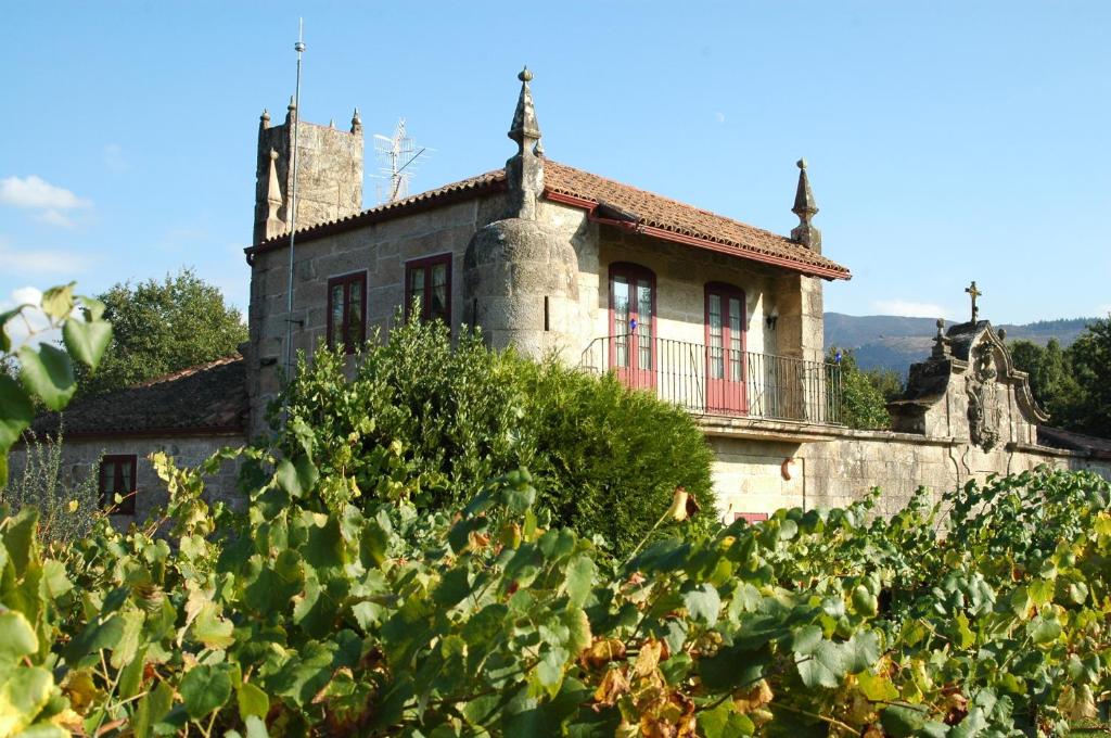 uma casa antiga no meio de um campo de vegetação em Pazo Da Fraga em Albeos