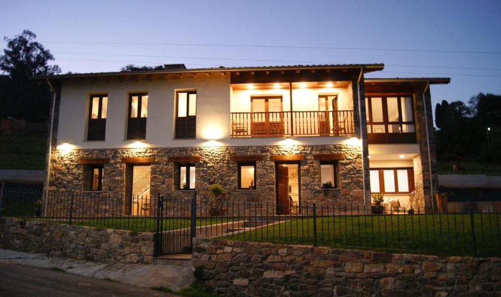 ein großes Steinhaus mit Lichtern daran in der Unterkunft Apartamentos Rurales Peñon Blanco in Peñerudes