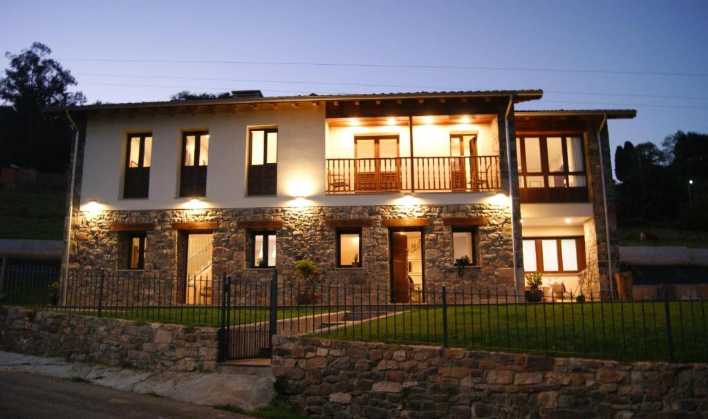 una gran casa de piedra con luces. en Apartamentos Rurales Peñon Blanco en Peñerudes