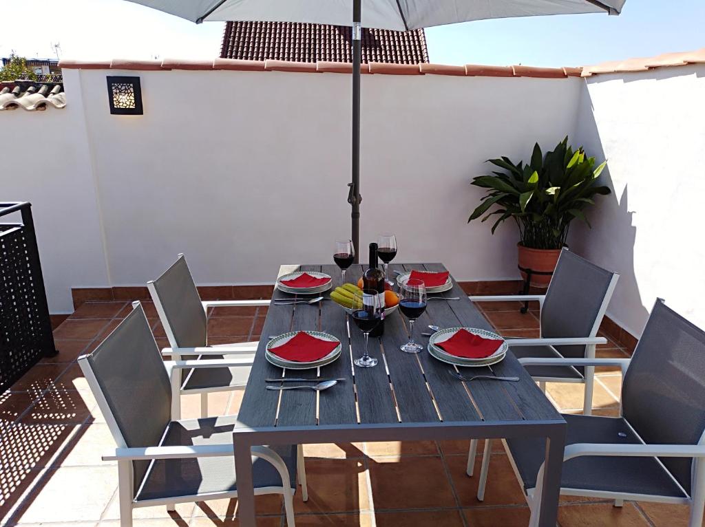 a blue dining table with chairs and an umbrella at Alzahira 1 in Córdoba