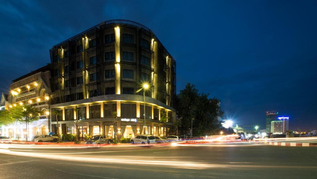 un edificio en una calle de la ciudad por la noche en Almond Hotel Bassac River, en Phnom Penh