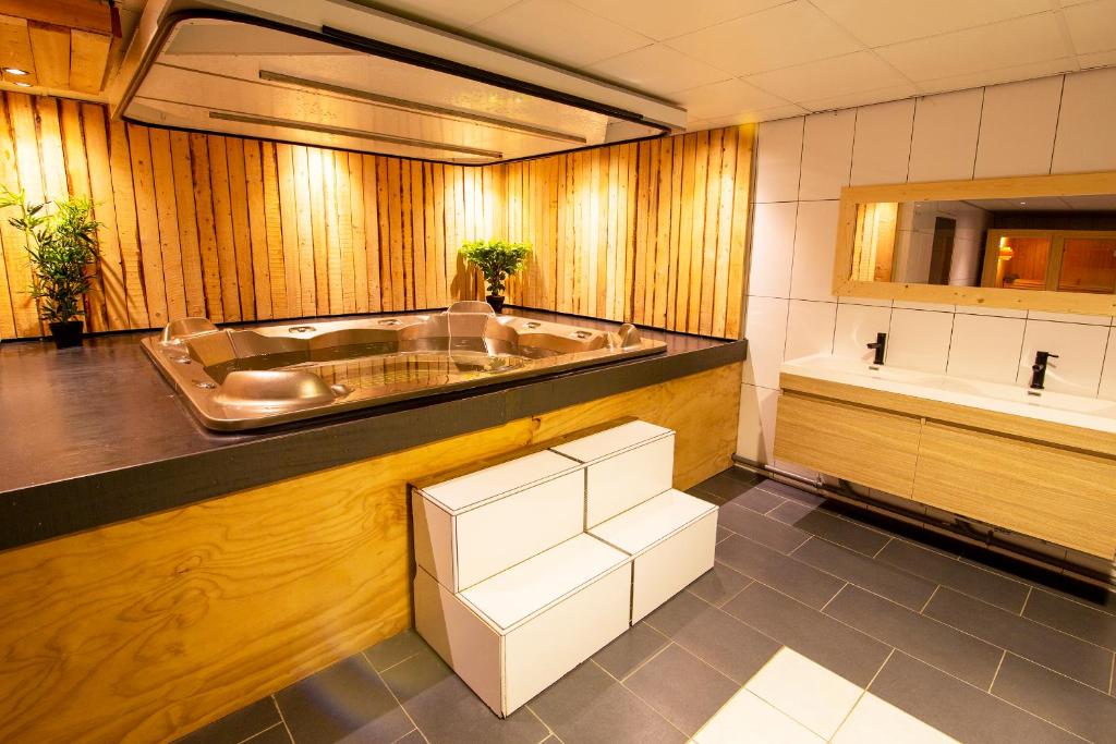 a bathroom with a tub and a sink at Luxus Familienvilla mit Jacuzzi & Sauna in Tzummarum