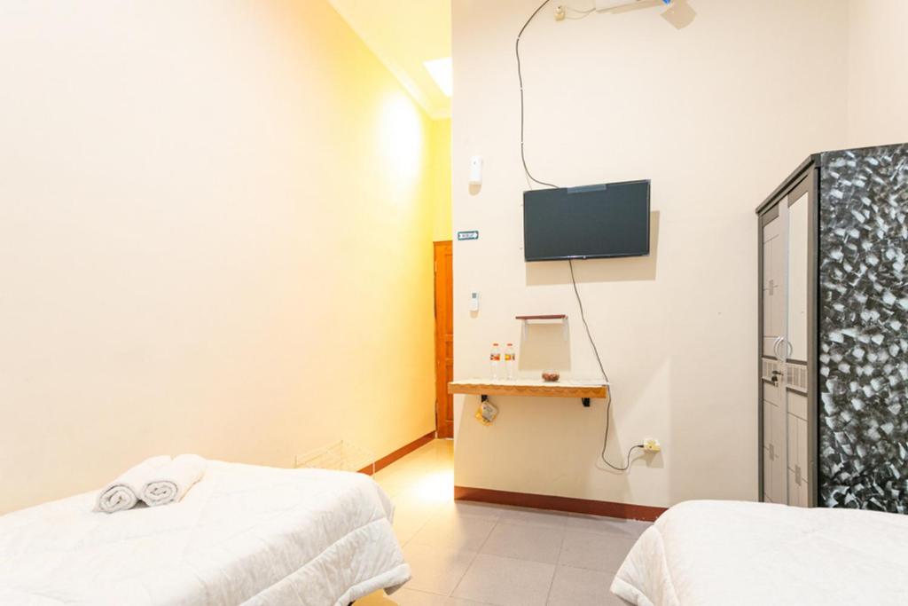 Postel nebo postele na pokoji v ubytování RedDoorz Syariah @ Sakinah Guesthouse