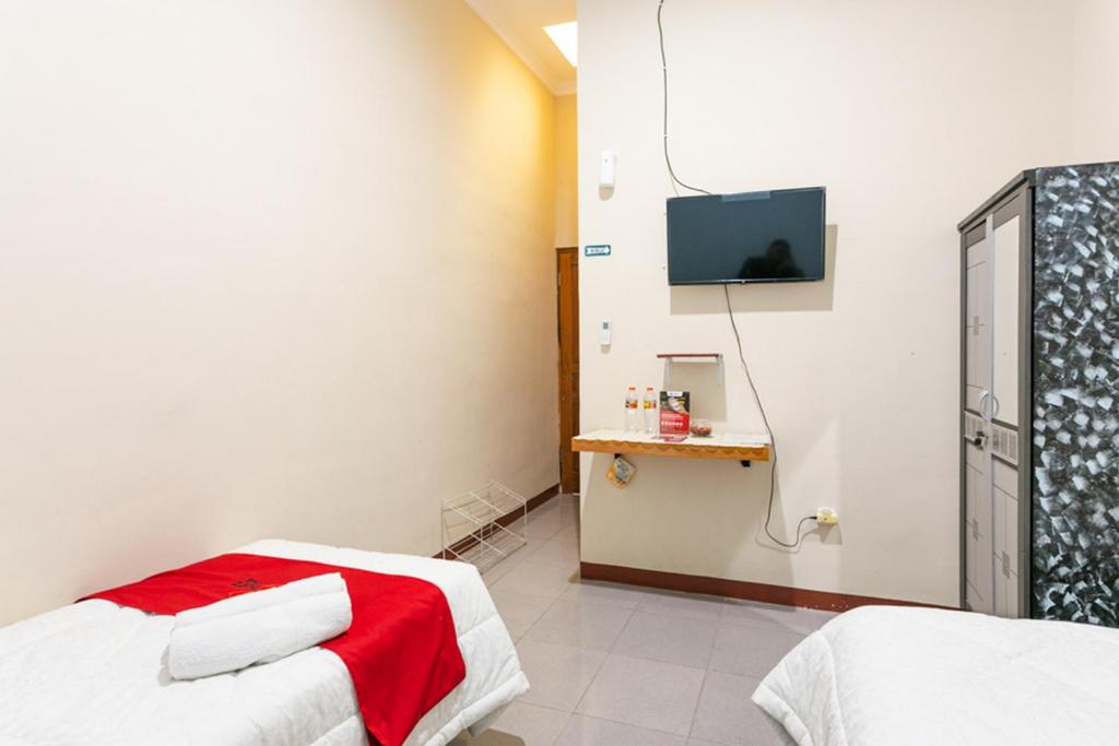 Postel nebo postele na pokoji v ubytování RedDoorz Syariah @ Sakinah Guesthouse