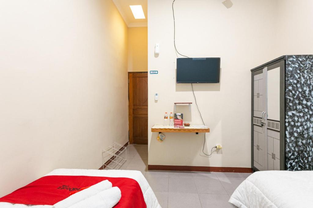 Postel nebo postele na pokoji v ubytování RedDoorz Syariah @ Sakinah Guesthouse