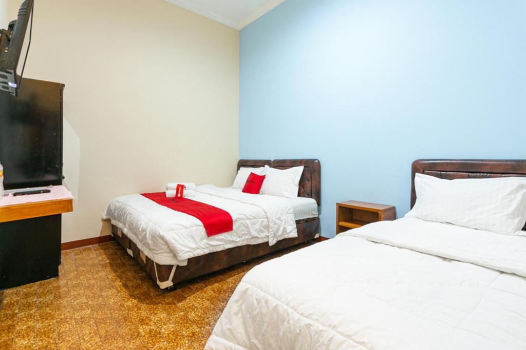 Postel nebo postele na pokoji v ubytování RedDoorz Syariah @ Sakinah Guesthouse
