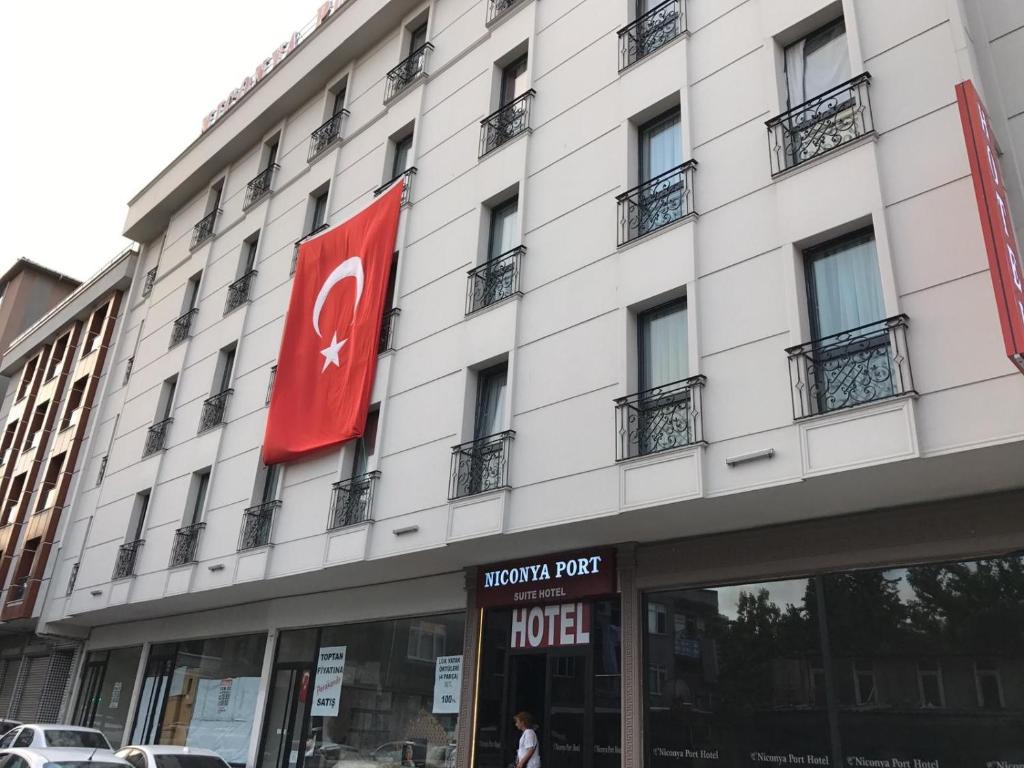 un gran edificio blanco con un letrero rojo. en Niconya Port Suite&Hotel en Estambul