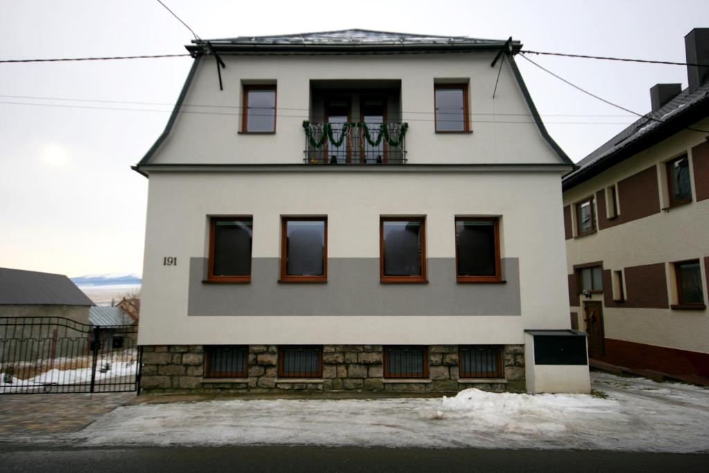 un bâtiment blanc avec des fenêtres et des plantes. dans l'établissement Privat Kohut, à Štrba