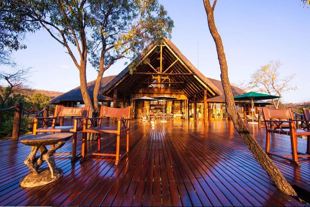 a wooden deck with chairs and a building at Metsi Lodge in Welgevonden Game Reserve