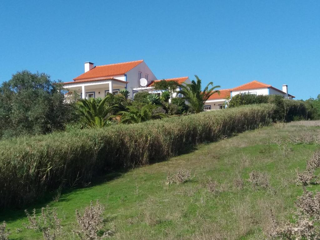 a house on top of a hill with grass at Água Rocha in Serra de Mangues