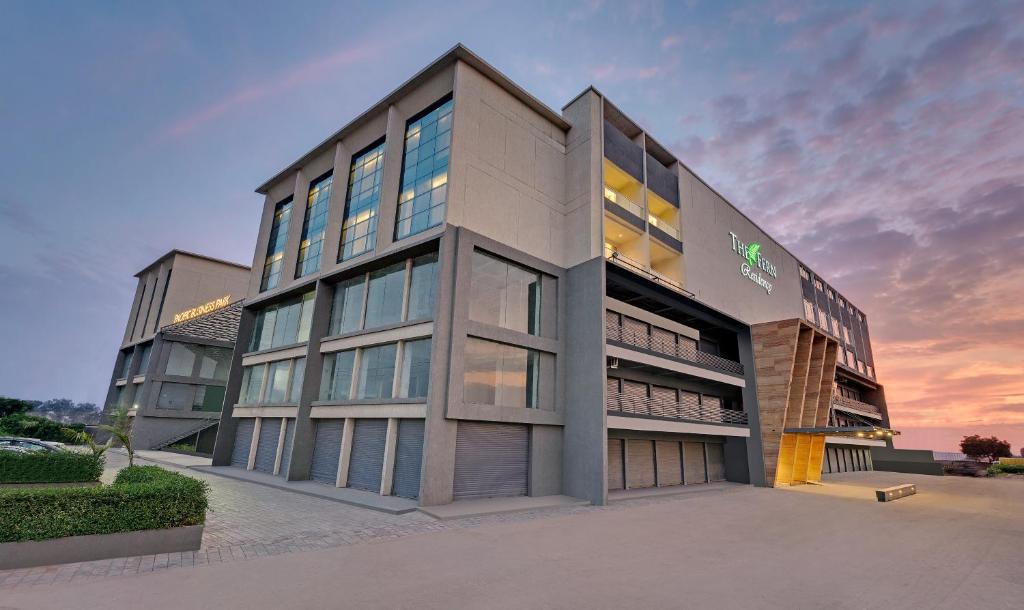 an office building with a sunset in the background at The Fern Residency, Morbi in Morbi
