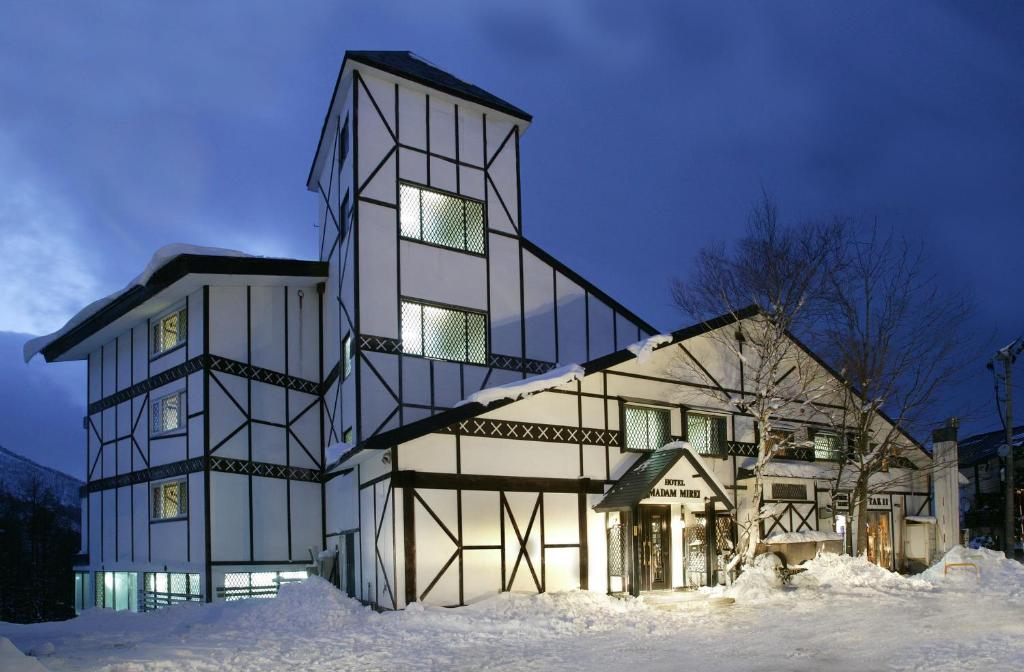 a large building in the snow at night at Hotel Madam Mirei in Iiyama