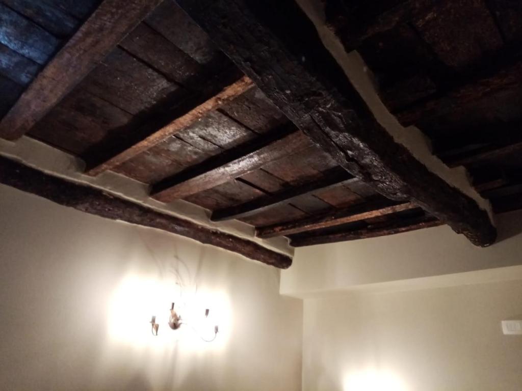 a room with a wooden ceiling and lights on the wall at Casa D'amore in Riomaggiore