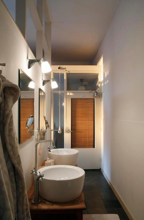 een badkamer met 2 wastafels en een spiegel bij Hotel het Oude Postkantoor in Brummen