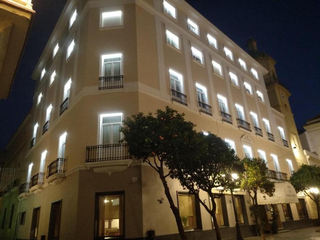 a large white building with lights on it at Hotel de Francia y París in Cádiz