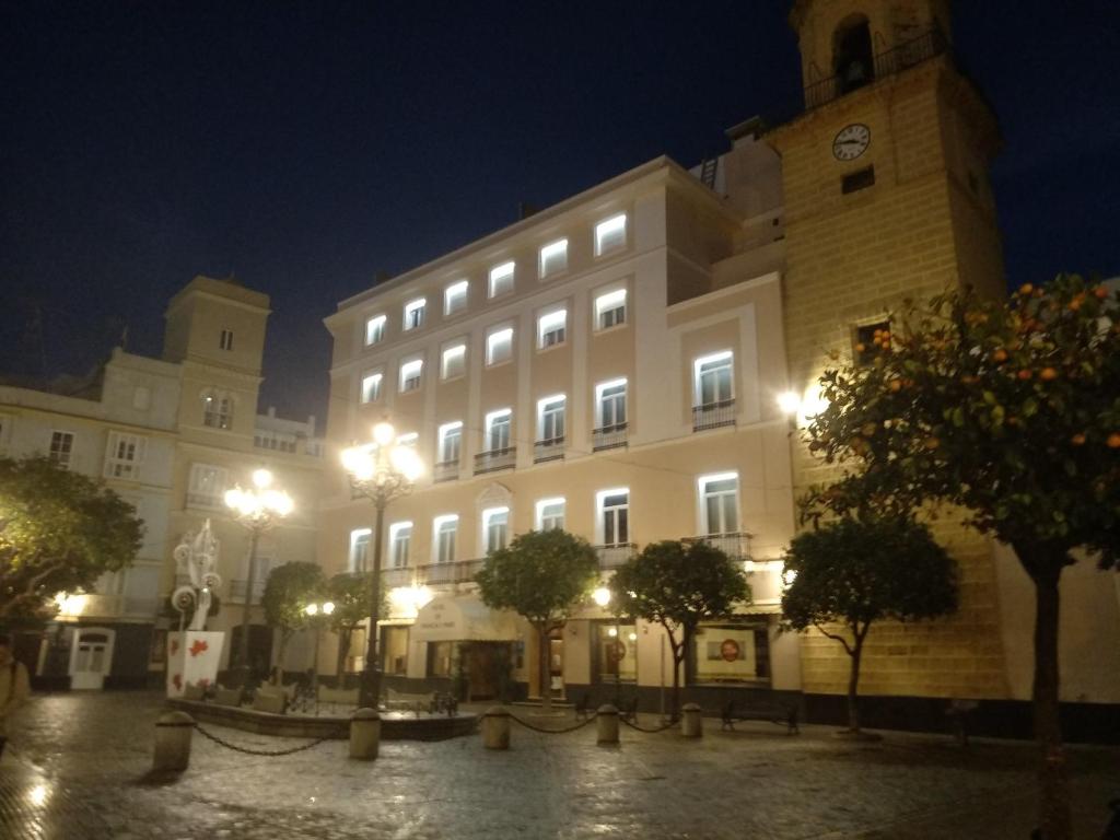 a large white building with a clock tower at night at Hotel de Francia y París in Cádiz