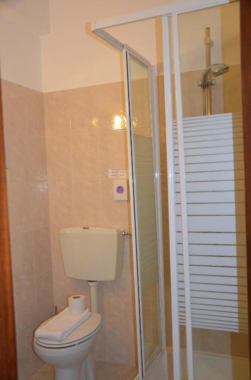 a bathroom with a toilet and a glass shower at ABLA Guest House in Carcavelos
