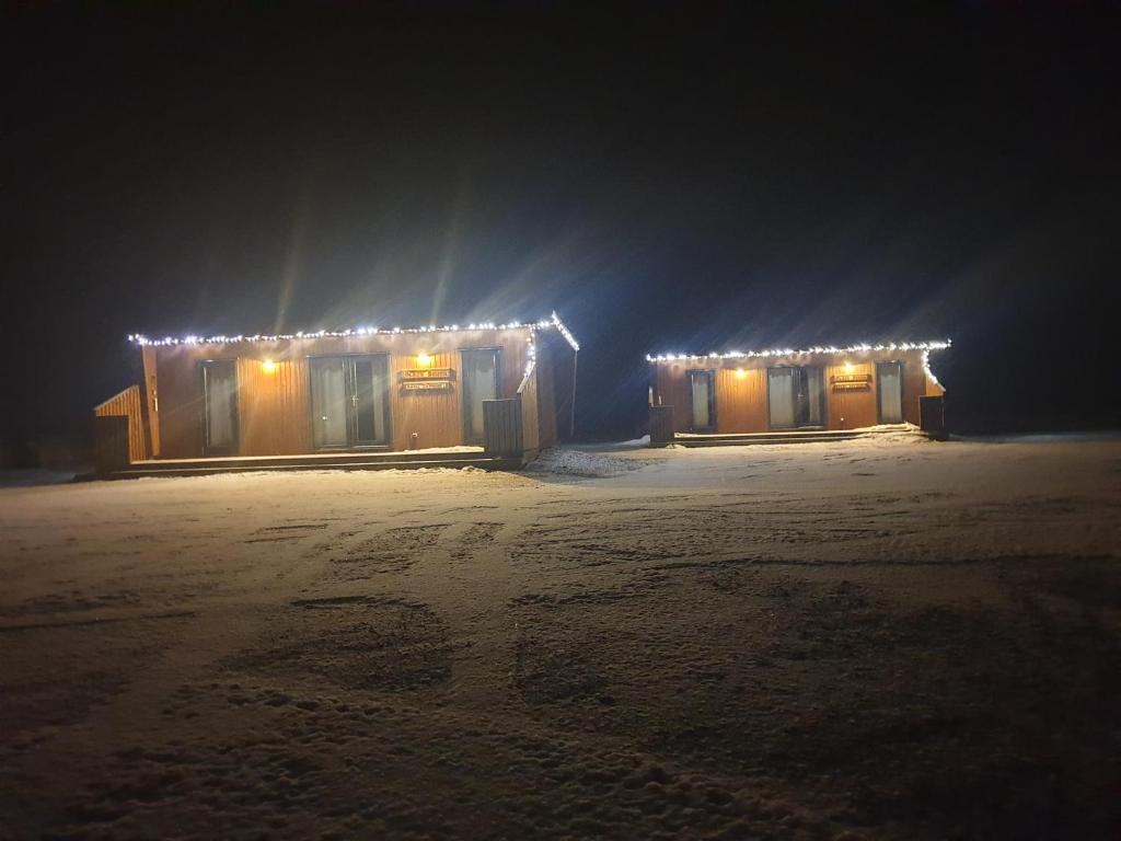 een gebouw met verlichting in de sneeuw bij Black Beach Cottage Small in Ölfus