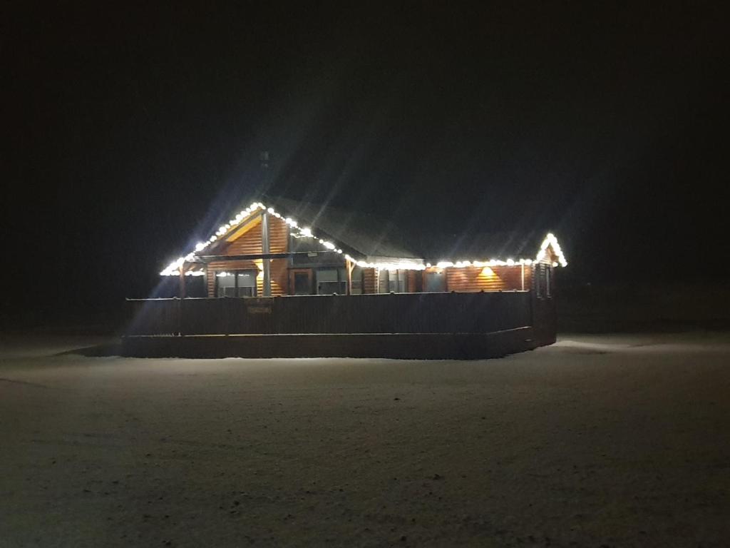 a wooden house with lights on it at night at Black Beach Cottage in Þorlákshöfn