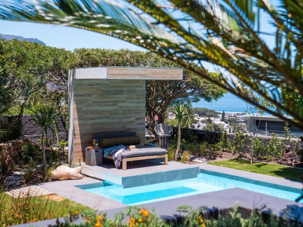 einen Hinterhof mit einem Pool mit einer Bank und einem Tisch in der Unterkunft Atholl House in Kapstadt