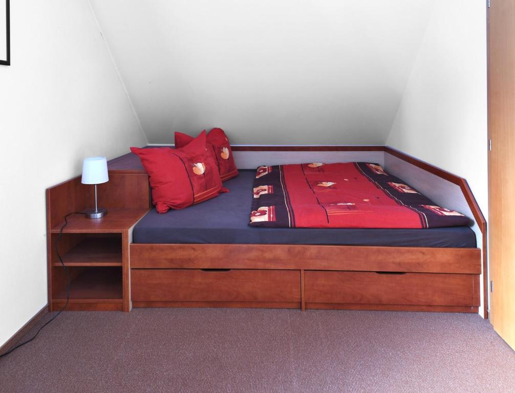 a bed with red pillows on top of it at Apartmán Bílé Labe in Špindlerův Mlýn