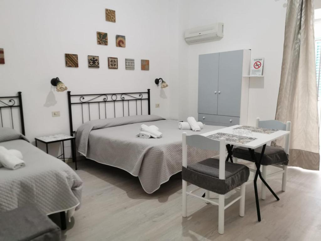 a bedroom with two beds and a table and a mirror at Lo Nardo Accommodation in Lipari