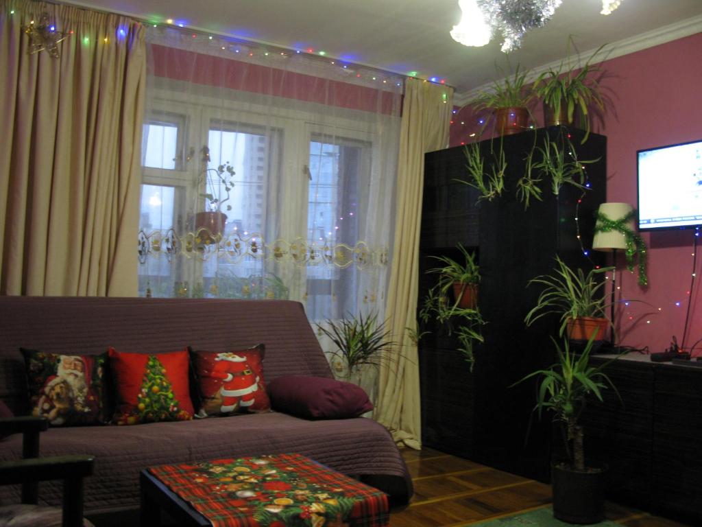 a living room with a couch and some plants at Apartment na Prospekt Bolshevikov 3 in Saint Petersburg