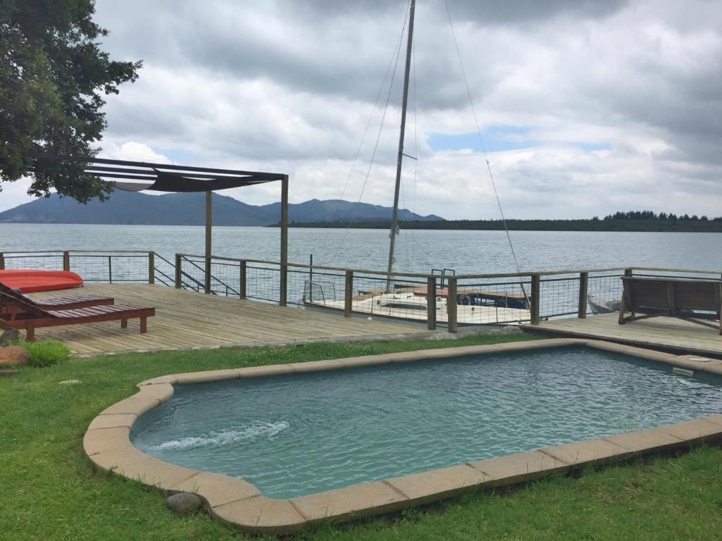 a swimming pool on a deck next to the water at Lodge Colbún in Colbún Alto