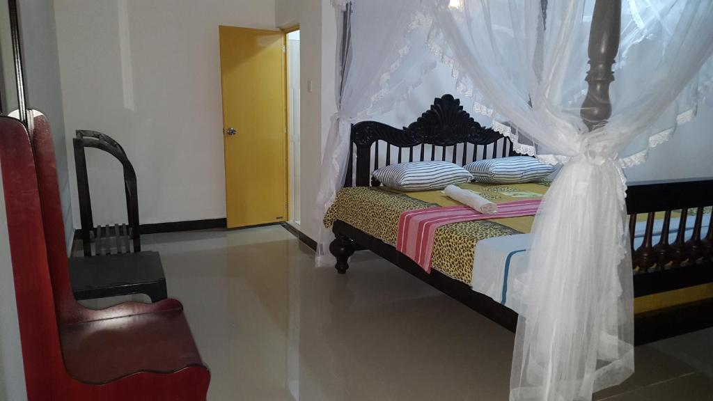 a bedroom with a bed with a mosquito net at Samudra Guest House in Mirissa
