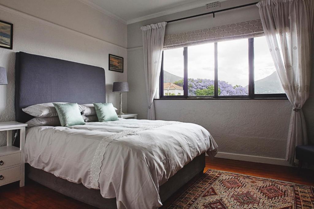 a bedroom with a large bed with a large window at One Above in Cape Town