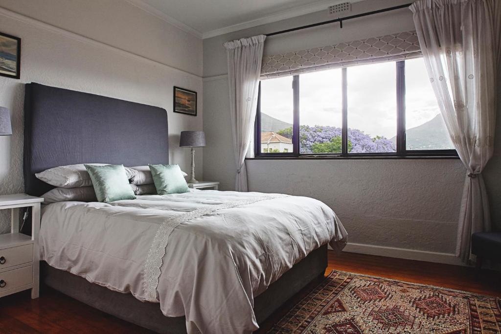 Un dormitorio con una cama grande con una ventana grande. en One Above, en Ciudad del Cabo