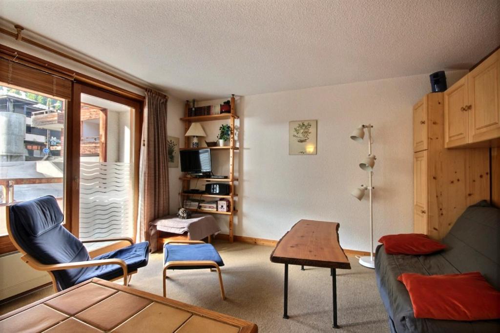 een woonkamer met een bank en een tafel bij STUDIO AVEC ACCES PISCINE - SAINT JEAN D'AULPS STATION - 4 PERSONNES - COFI S31 in Saint-Jean-dʼAulps