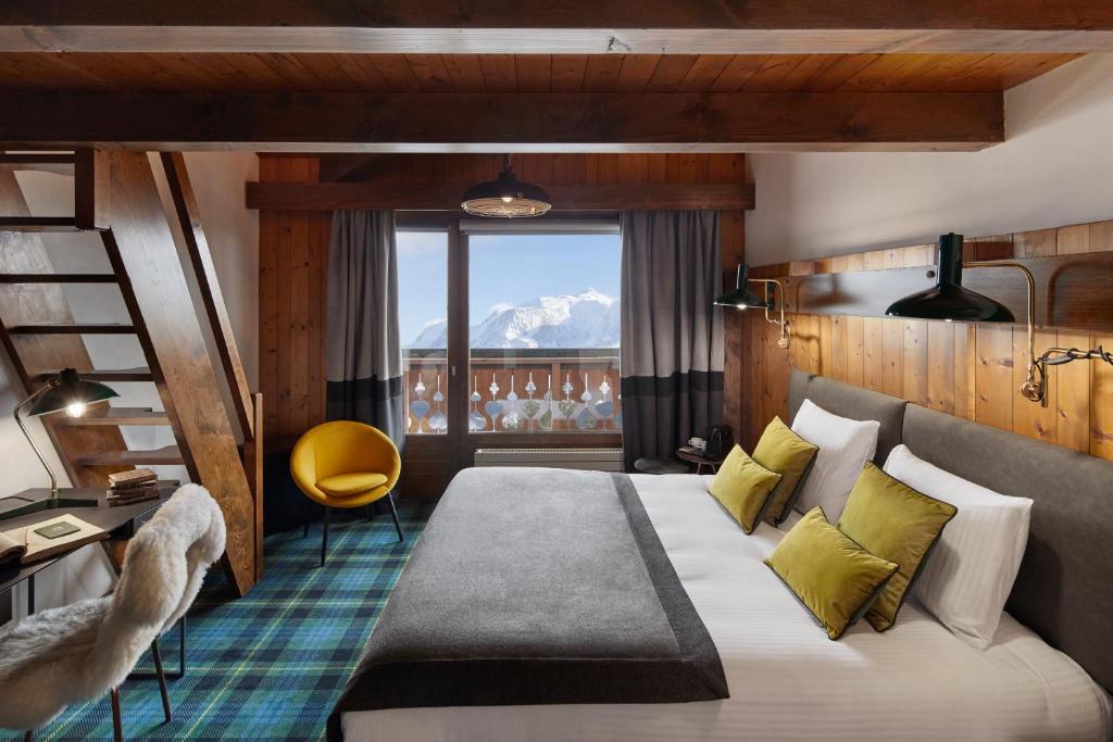 a hotel room with a bed and a balcony at Chalet Alpen Valley, Mont-Blanc in Combloux