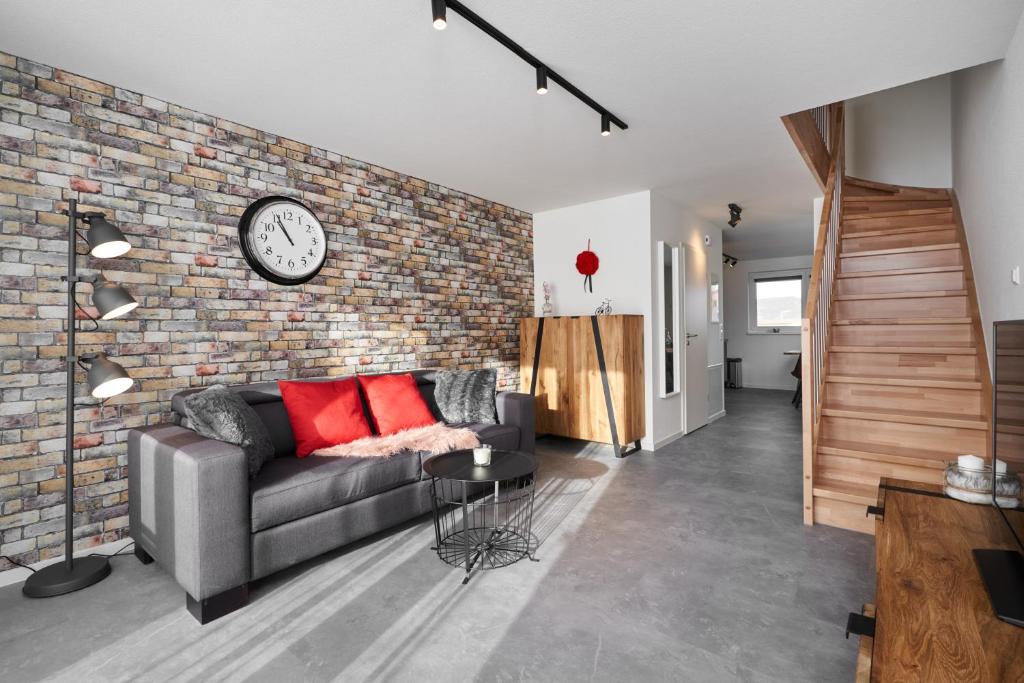ein Wohnzimmer mit Sofa und Ziegelwand in der Unterkunft Boutique Apartments Kirchzarten in Kirchzarten