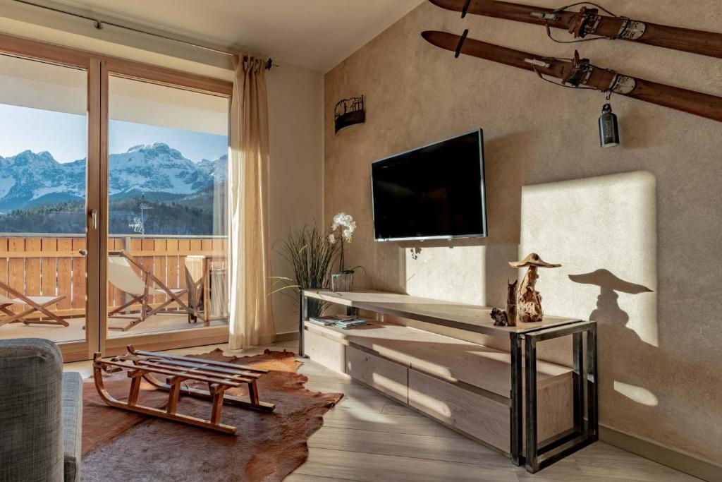 salon z telewizorem z płaskim ekranem na ścianie w obiekcie Appartamento Lusso Panoramic - Andalo w Andole